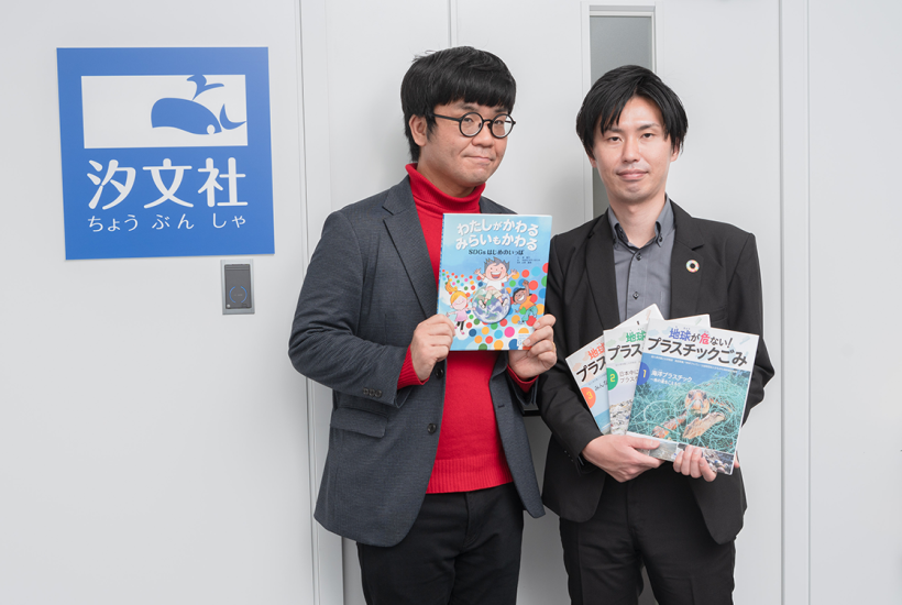 汐文社の門脇大副編集長(左)と、営業部の岡﨑大輔係長(右)。岡﨑さんが手に持つ『地球が危ない! プラスチックごみ』全3巻も、ゴール14「海の豊かさを守ろう」などのSDGsに関連する内容の書籍。