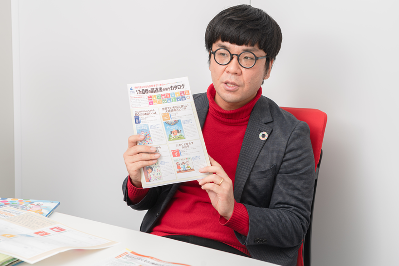 門脇副編集長が手に持っているのは、SDGsの17のゴールに合わせて汐文社の書籍を解説するカタログ