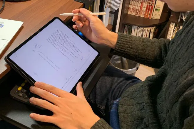 iPadで原稿への赤入れを行っている様子